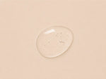 Clear droplet with bubbles on a beige background